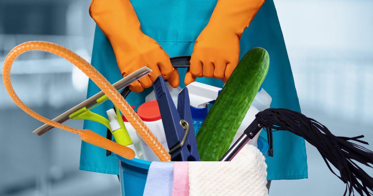 Putzkraft hält einen Emer bit Putz und BDSM Utensilien hoch
