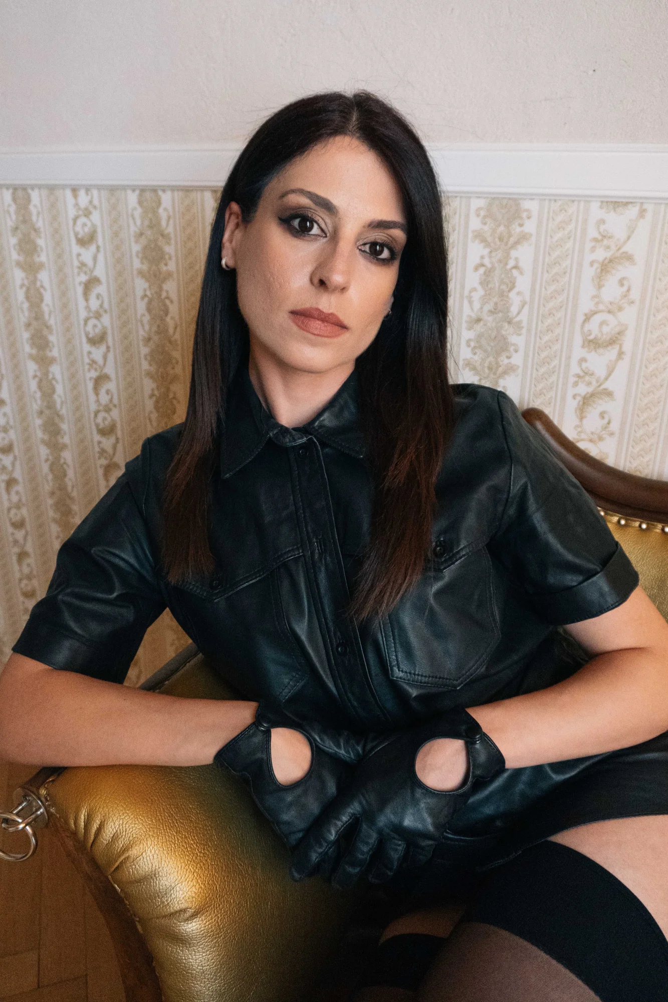 Aido Akida is wearing black leather dress and black leather gloves