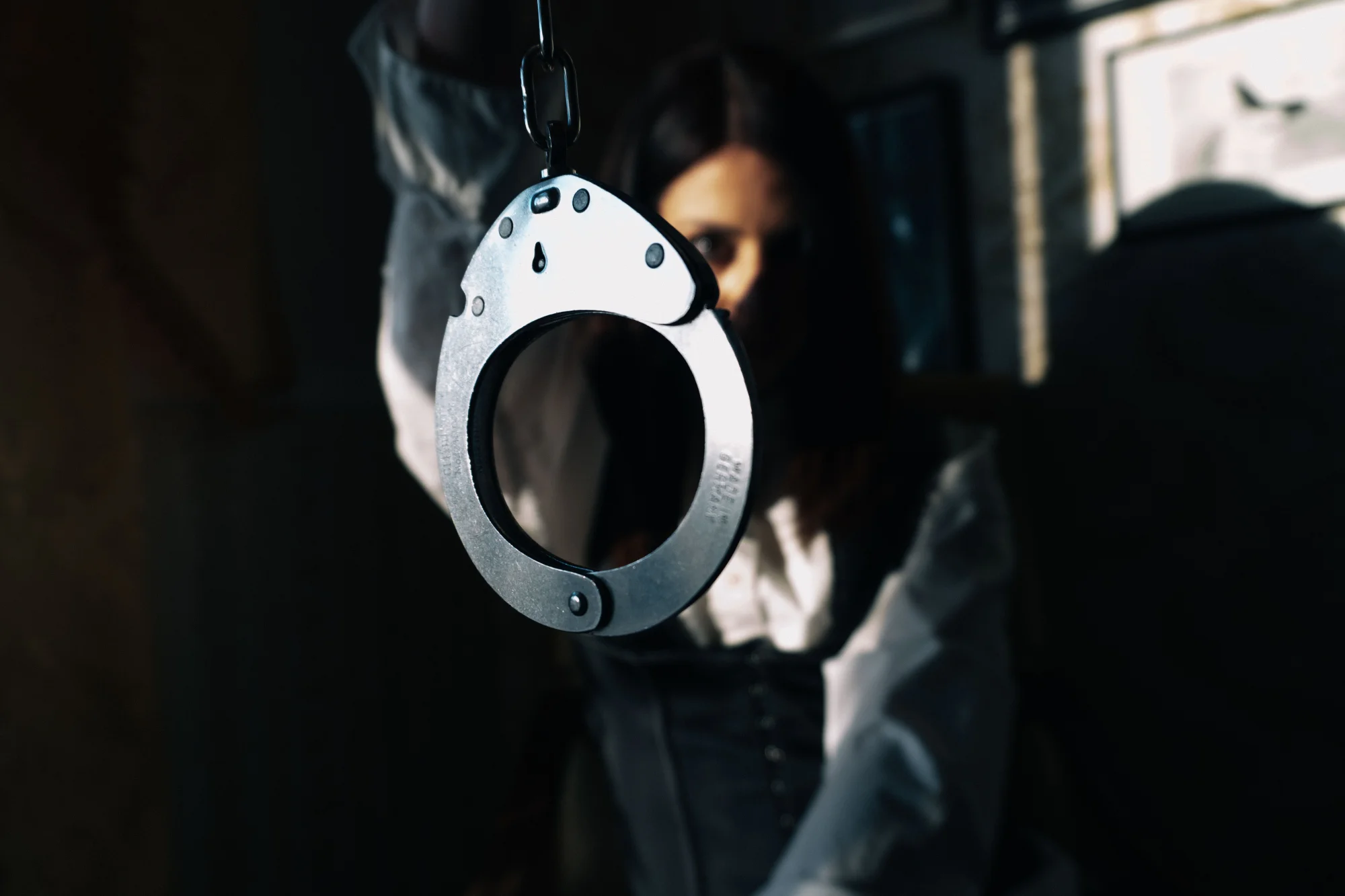 Aido Akida holding a pair of handcuffs