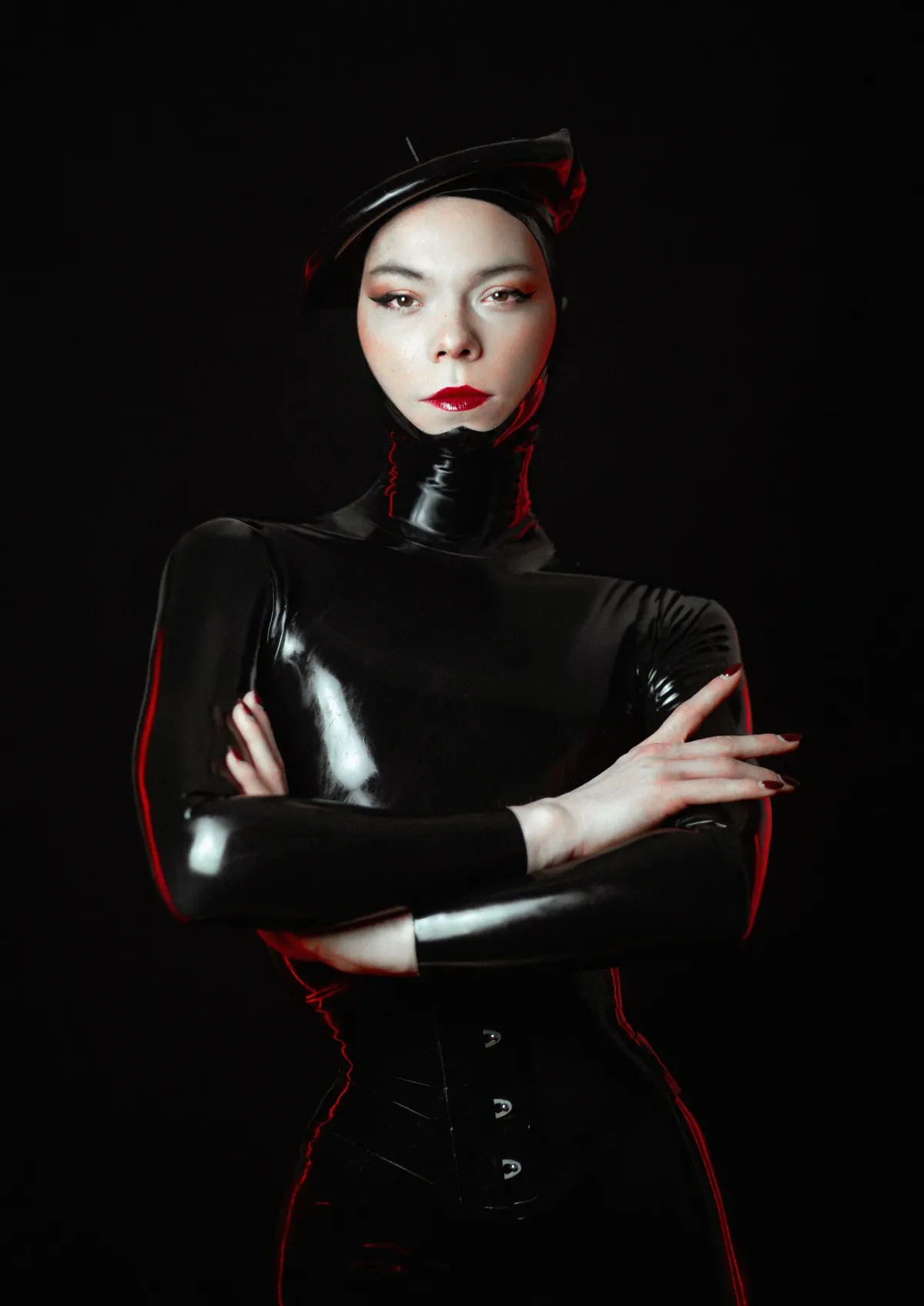 french mistress wearing full black latex with long nails and a beret
