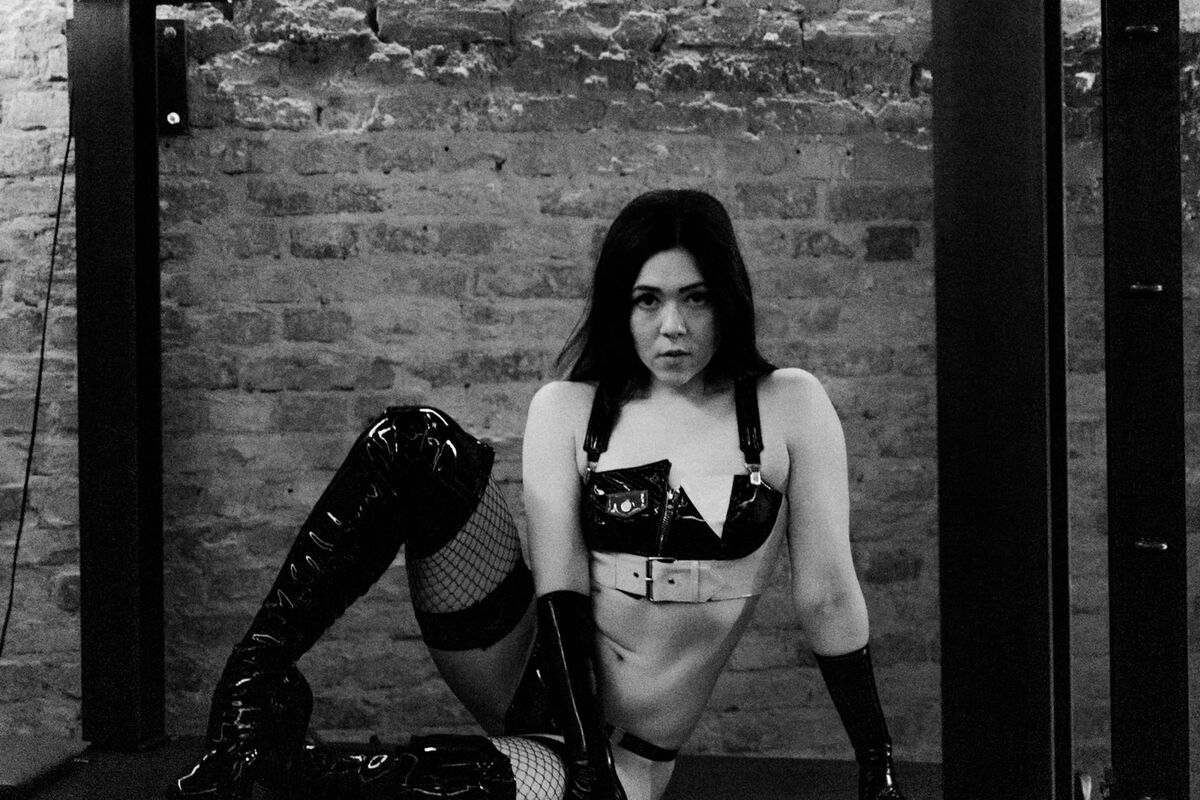 Anki Slay – Berlin Dominatrix in latex gloves, PVC top and thigh-high boots in BDSM dungeon studio