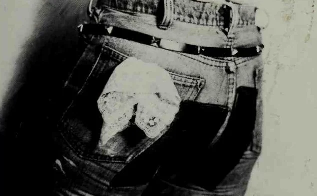 a leatherdyke wearing jeans and a hankerchief in the back
