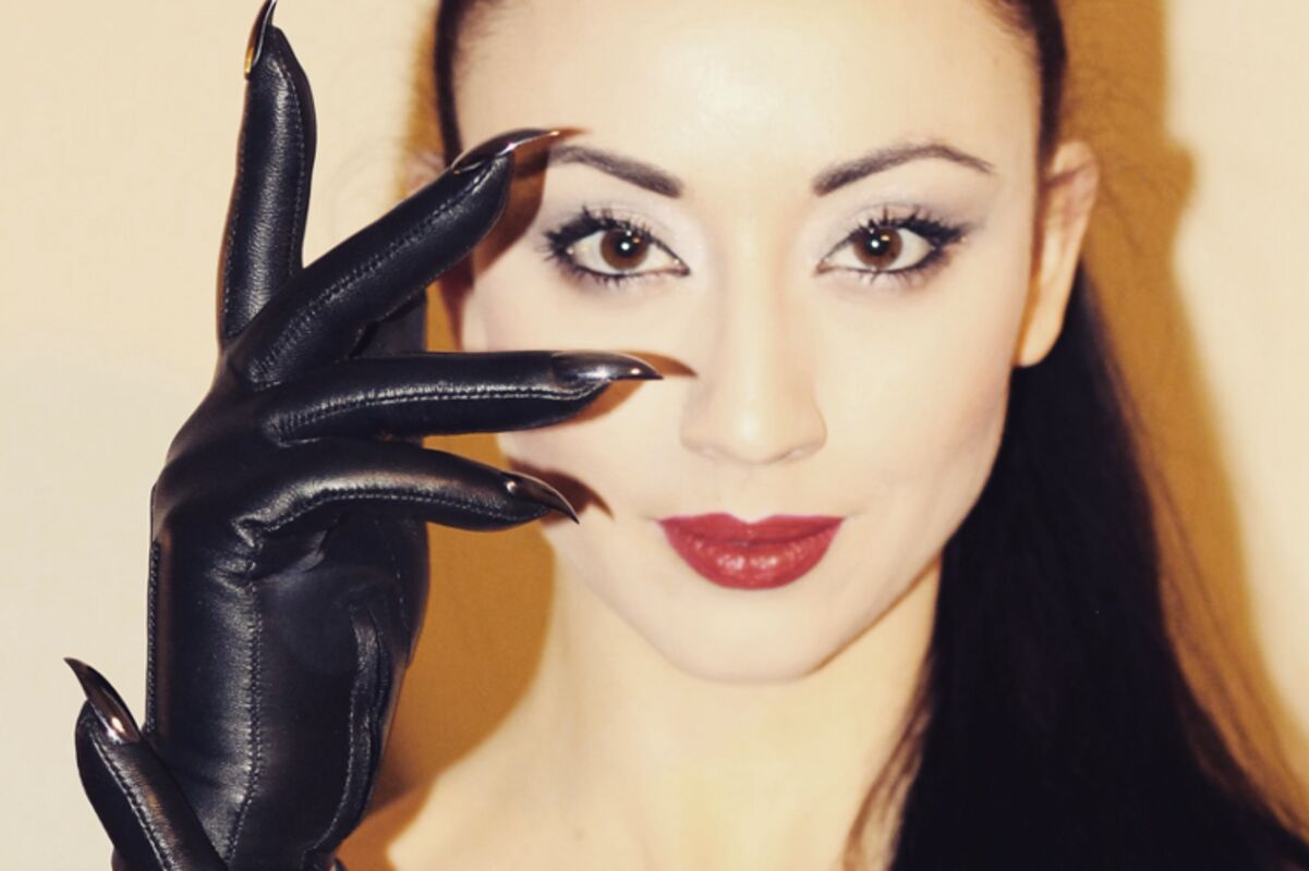 A portrait of Lady Mephista wearing her signature Majesty Black opera gloves with metal claws, her eyes and lips are accentuated.