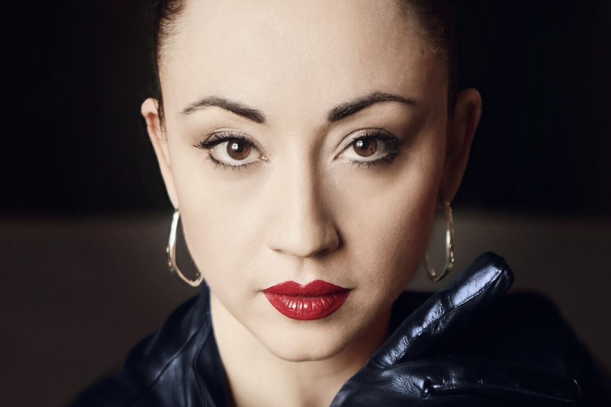 Dressed in a blush lavish silk corset and a felt hat that remdinds the viewer of a secret agent, Lady Mephista positions herself in front of the government district of Berlin. Her outfit is both soft and provocative, she's aware of your gaze and ready to take control.