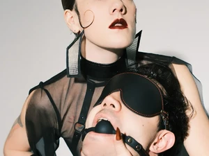 Lady Solar Divine im Harness mit langen Nägeln mit einem Sub mit Augenbinde und Knebel im Studio Lux Berlin Domina Switch