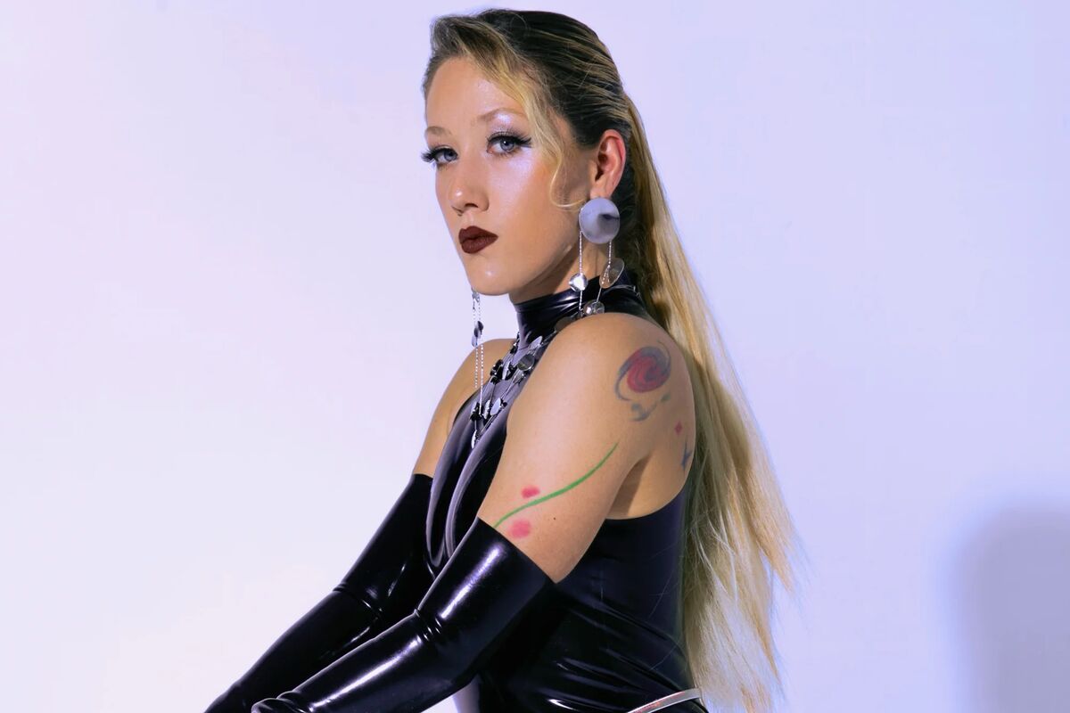 Lady Solar Divine in schwarzem Latexanzug und Handschuhen im Studio Lux Berlin