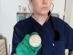 Doktor Lara Vixette hört mit Stethoskop und grünen Nitril Handschuhen Patienten in der Klinik in Berlin ab