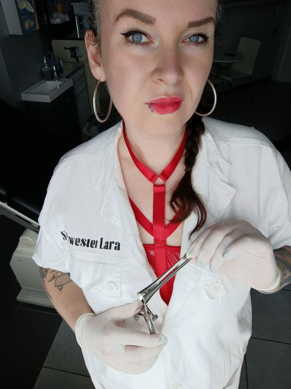 Schwester Lara bereitet das Spekulum mit weißen Latex Einweghandschuhen vor