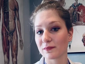 Portrait of Bizarrlady Lina Twist as a doctor in a white coat over a purple top at the Studio LUX Berlin clinic.