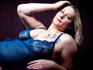 Bizarrlady Lina Twist shows off her sensual curves in a blue lace bodysuit at Studio LUX Berlin.