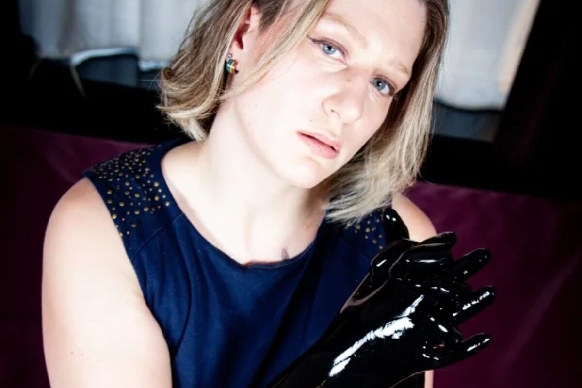 Bizarrlady Lina Twist reibt sich vorfreudig die Hände in schwarzen Latexhandschuhen mit Silikonöl.