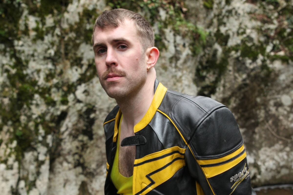 Blonde man in leather biker jacket and yellow rubber vest
